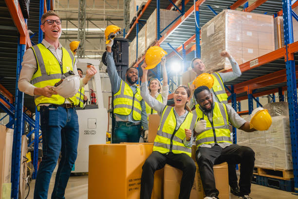 istock Group of happy warehouse workers celebrating success in warehouse 1495211285