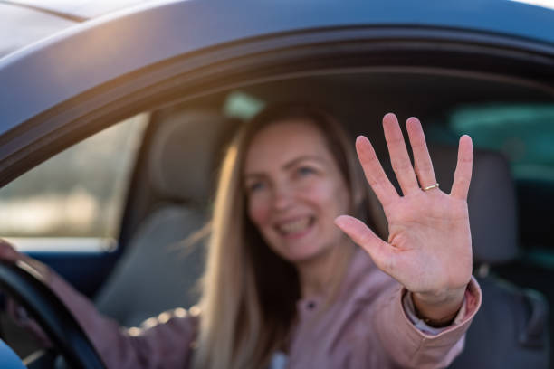 istock a woman waves from the car 1495211465