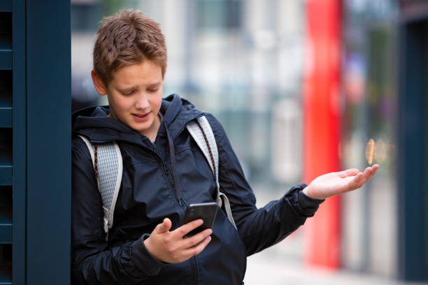Teenage school boy talking with friend on video call on mobile phone stock photo