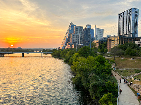 Austin, Texas, USA- April 2023: Austin Taxes skyline at sunset with people walking along the river