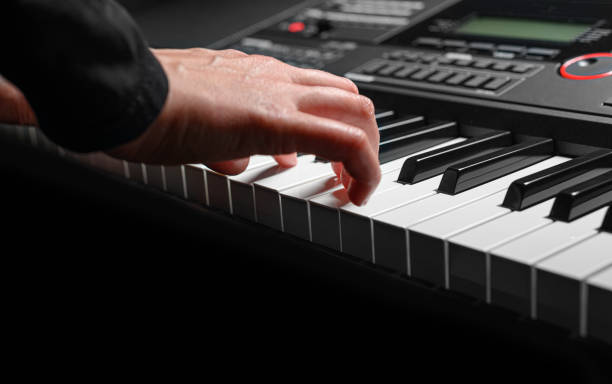 istock Playing the piano synthesizer on dark background 1495213282