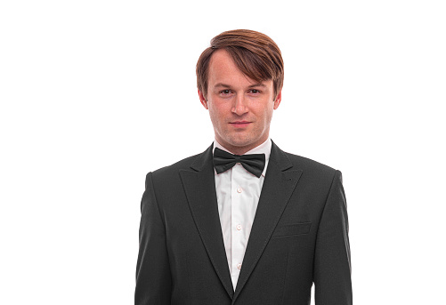 Waist up composition of a mature man with an excited expression wearing a tuxedo and isolated on white background 