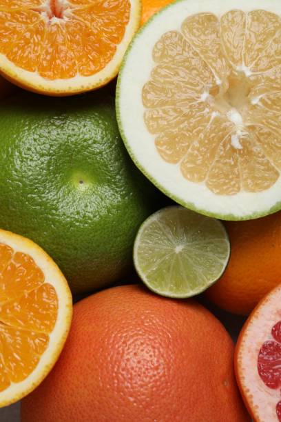 istock Different fresh whole and cut citrus fruits as background, top view 1495216401