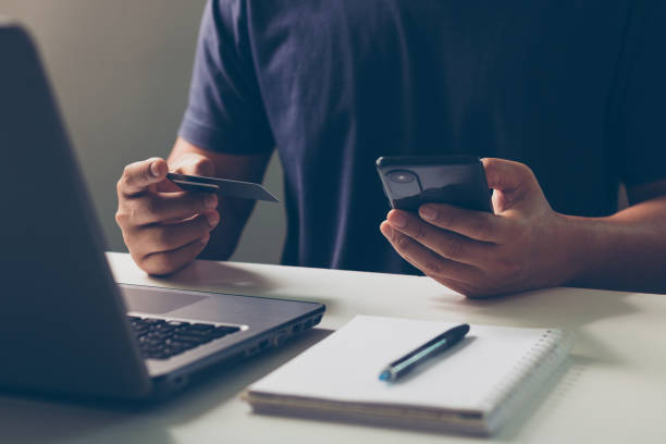 istock Online shopping concept. Man makes a purchase on the Internet on their smartphone with a credit card, online payment, shopping online, e-commerce, internet banking, and spending money. 1495216496