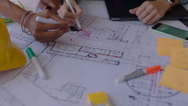 close up hands architects using building plans business women working together on construction project team of engineers brainstorming design solution planning successful development strategy