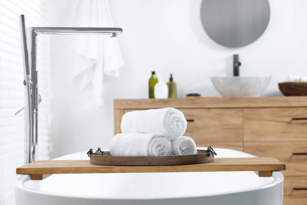 istock Rolled bath towels on tub tray in bathroom 1495222920