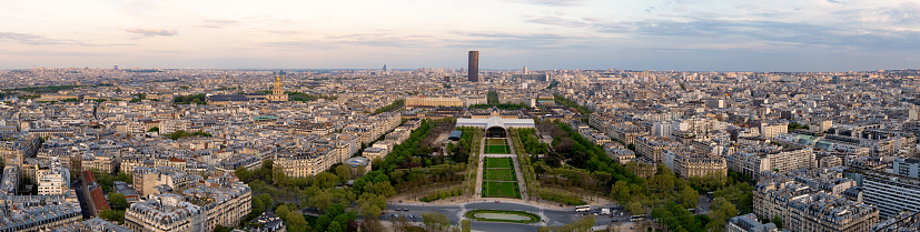 Paris aerial panorama and Champ de Mars from Tour Eiffel, France. Romantic summer holidays vacation destination. Panoramic view above historical Parisian buildings and landmarks with sunset sky