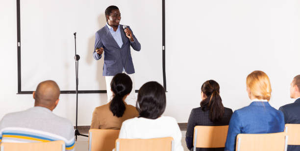 istock Positive African American with microphone speaking at business event 1495223054