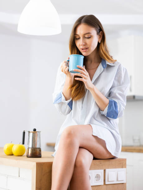 istock Woman drinking coffee at kitchen in morning 1495224173