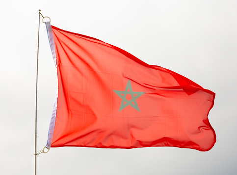 Flag of morocco flying proudly in wind with sky as background