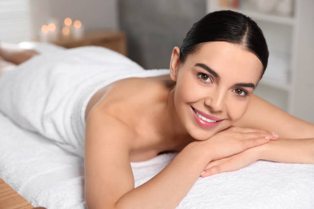 istock Beautiful happy woman relaxing on massage table in spa salon 1495227135