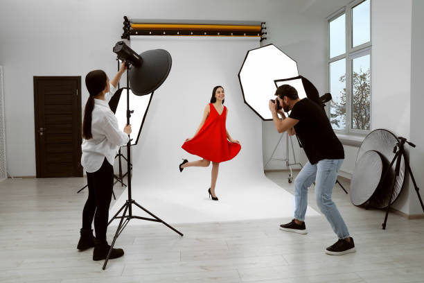 istock Professional photographer and assistant working with beautiful model in modern photo studio 1495227184