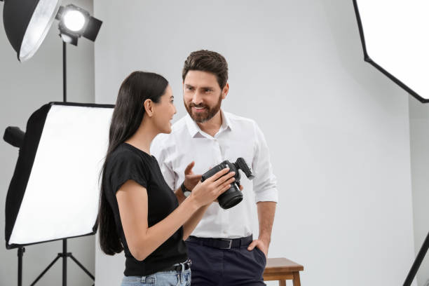 istock Professional photographer and model looking at pictures on camera in modern studio 1495227199