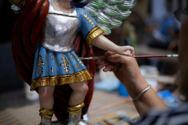 Woman restoring statue of St. Michael