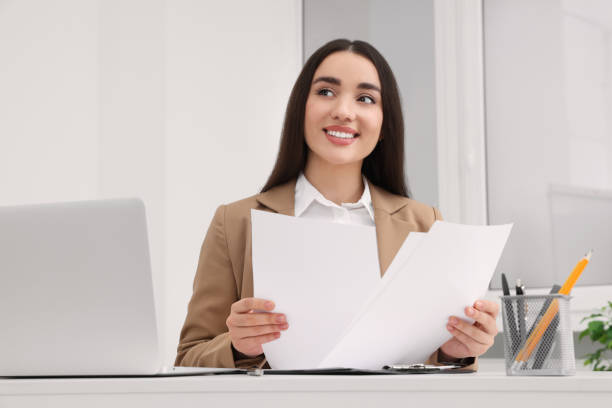 istock Young female intern working with laptop at table in office 1495227424