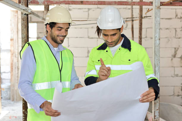 istock Two technician civil engineer or specialist inspector discussing, brainstorm and planing work with laptop, blueprint and walkie talkie radio together at Industrial building site. Construction concept 1495230094