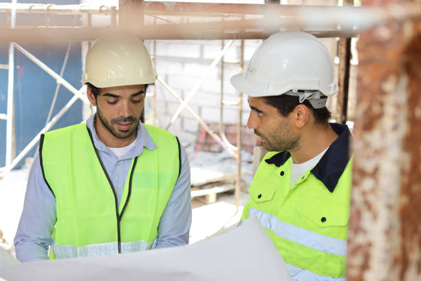 istock Two technician civil engineer or specialist inspector discussing, brainstorm and planing work with laptop, blueprint and walkie talkie radio together at Industrial building site. Construction concept 1495230110