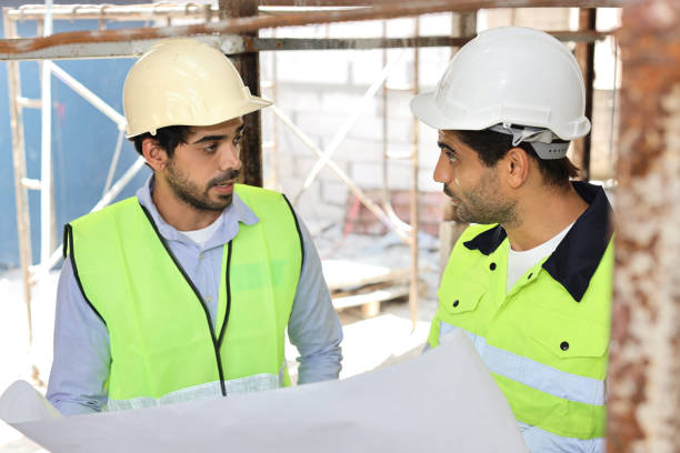istock Two technician civil engineer or specialist inspector discussing, brainstorm and planing work with laptop, blueprint and walkie talkie radio together at Industrial building site. Construction concept 1495230126