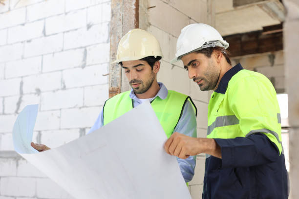 istock Two technician civil engineer or specialist inspector discussing, brainstorm and planing work with laptop, blueprint and walkie talkie radio together at Industrial building site. Construction concept 1495230231