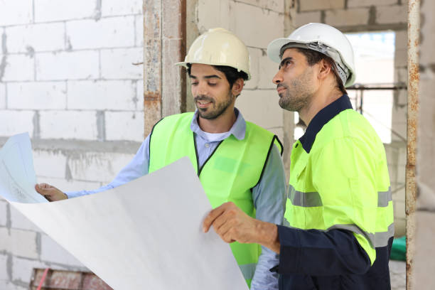istock Two technician civil engineer or specialist inspector discussing, brainstorm and planing work with laptop, blueprint and walkie talkie radio together at Industrial building site. Construction concept 1495230260