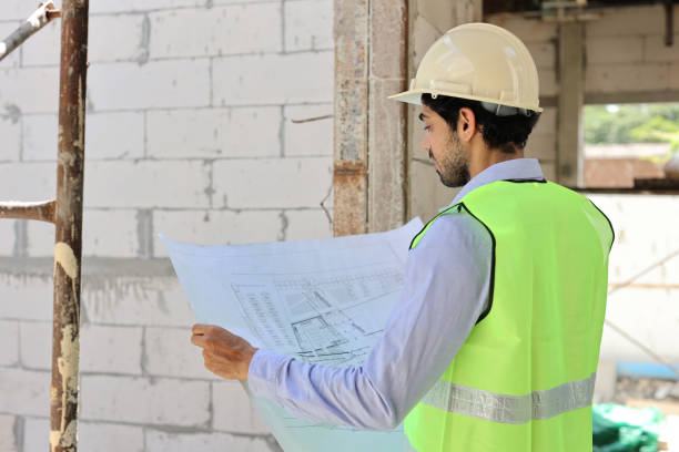 istock Technician civil engineer or specialist inspector discussing, brainstorm and planing real estate project work with smart mobile phone and blueprint at Industrial building site. Construction concept 1495230778