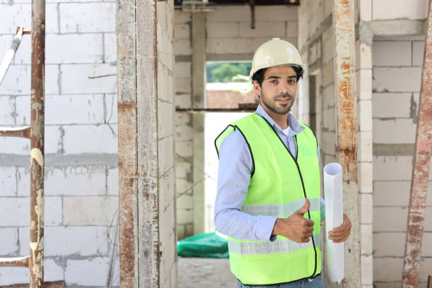 istock Technician civil engineer or specialist inspector showing thumb up while holding blueprint and look at camera with happy face after project complete at Industrial building site. Construction concept 1495230802