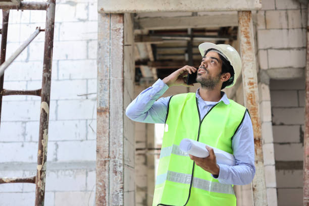 istock Technician civil engineer or specialist inspector discussing, brainstorm and planing real estate project work with smart mobile phone and blueprint at Industrial building site. Construction concept 1495231256