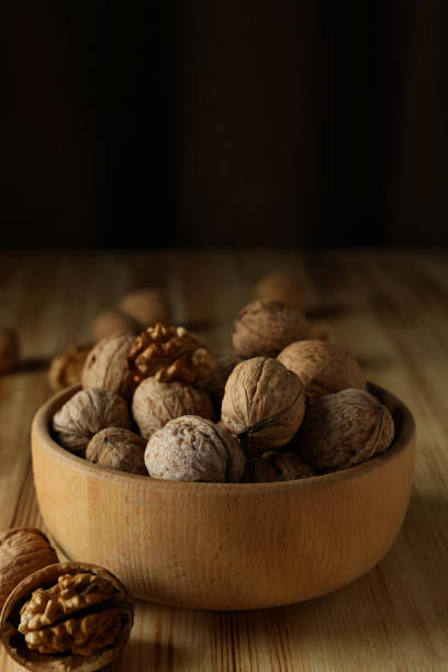 istock Walnuts in wooden bowl on wooden table 1495231446