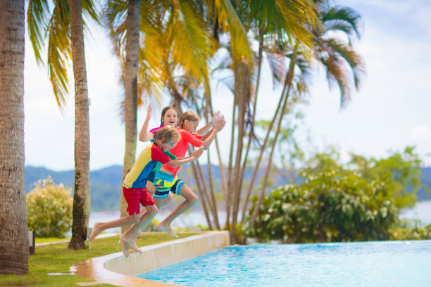 istock Kids jump into swimming pool. Summer water fun. 1495231523