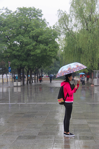 Beijing, China - May 14th 2016 - Chinese People Walking in Rainy Time in Beijing Tiananmen Square