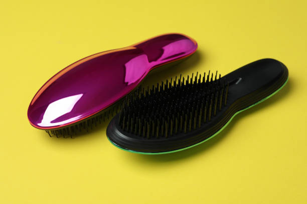 istock Colored plastic hair brushes on yellow background 1495232027