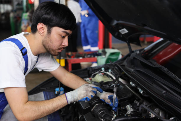 istock Man technician car mechanic in half uniform checking maintenance a car service at repair garage station. Worker holding wrench and fixing breakdown vehicle. Concept of car center repair service. 1495233020