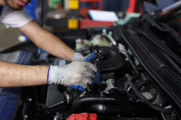 istock Man technician car mechanic hamds in half uniform checking maintenance a car service at repair garage station. Worker holding wrench and fixing breakdown vehicle. Concept of car center repair service. 1495233021