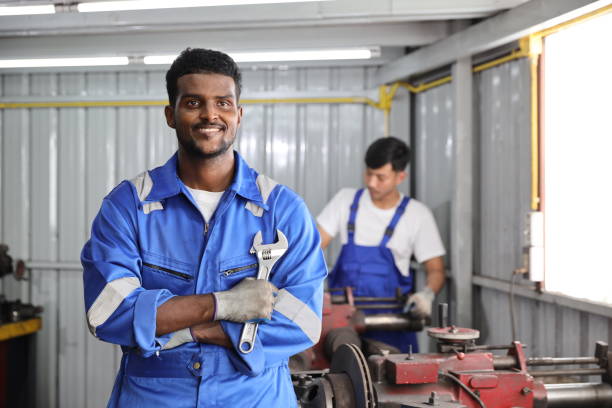 istock Technicain mechanic crossed arms with wrench and confident while working on metal lathe machine operate polishing car disc brake at garage. Maintenance automotive and inspecting vehicle part concept 1495233438