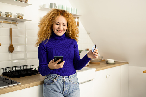 Beautiful, young woman shopping online from home