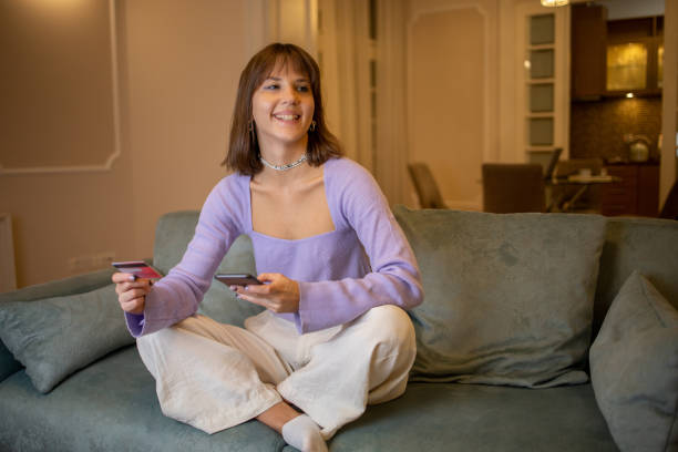 istock Cheerful  woman doing online shopping 1495236922