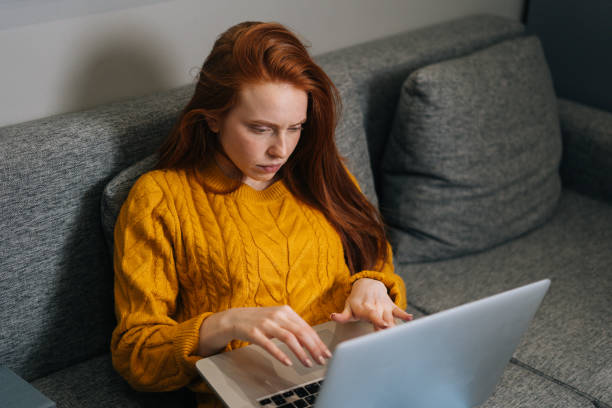 istock High-angle view of sad female freelancer feeling tired worried about problem sitting on sofa with laptop. Stressed young woman troubled with reading bad news 1495237030