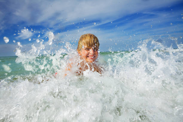 istock Boy play in ocean wave with water splashes during vacations 1495237193