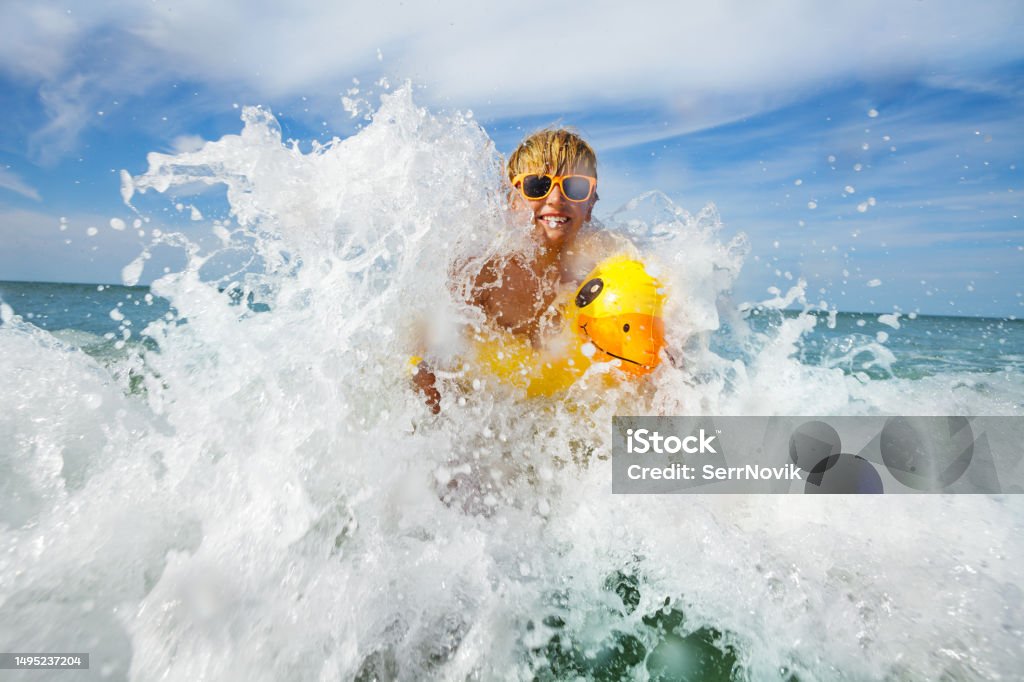 Diversión en el mar - niño con gafas de sol y pato inflable amarillo - Foto de stock de Agua libre de derechos Diversión en el mar - niño con gafas de sol y pato inflable amarillo - Foto de stock de Agua libre de derechos