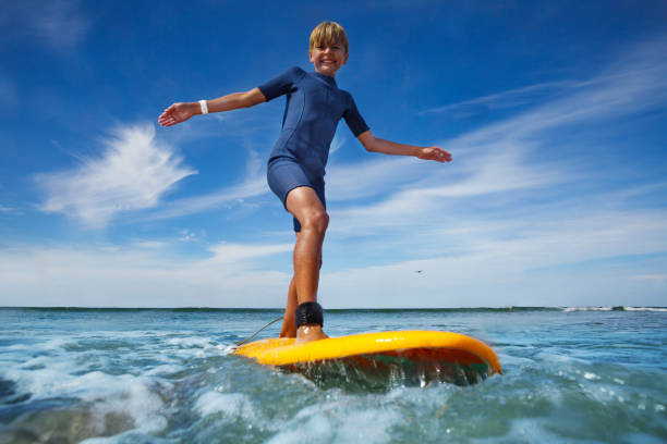 istock Boy stand on the surf board smiling balancing with hand 1495237261