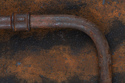 Rusty valve pipes on rusty metal wall background