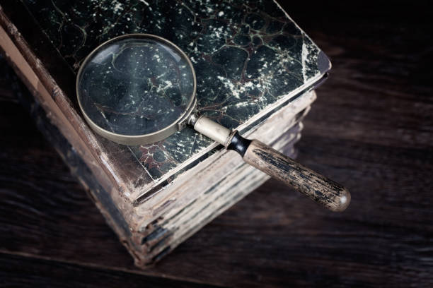 istock Old vintage magnifying glass with books on table 1495237936