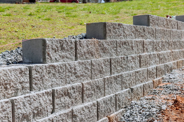 un mur de soutènement est construit dans le cadre de la construction d’une nouvelle maison près d’une propriété où le mur doit être construit. - landscaped retaining wall wall stone photos et images de collection