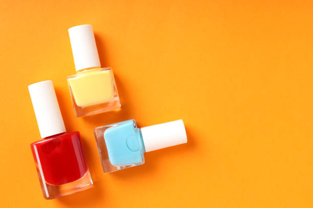 istock Nail polish on orange background, close up 1495239410