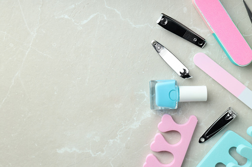 Concept of nail care with manicure accessories on light textured background