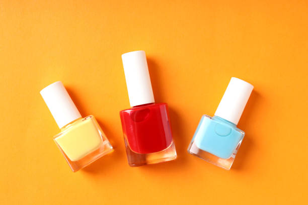 istock Nail polish on orange background, close up 1495241045