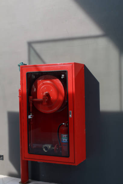istock Red fire extinguisher system on concrete wall under sunlight. Fire safety. Powerful emergency equipment for industrial 1495242257