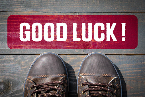 Good Luck. Motivation and inspiration concept. Street shoes on a wooden texture background.