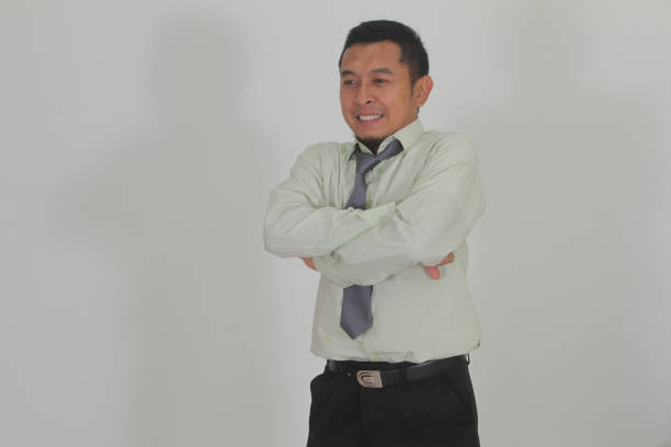 Indonesian man thinking and contemplating type while standing on white background isolated