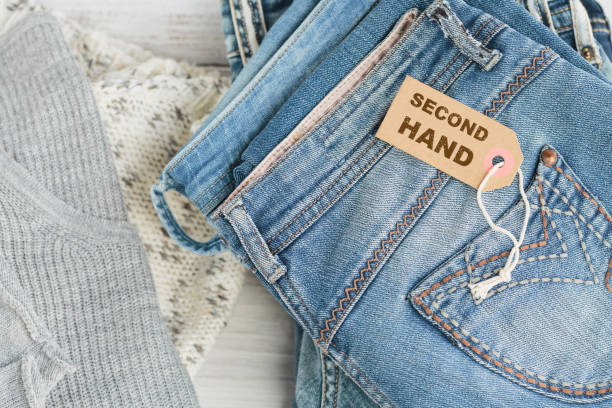 istock Stack of blue jeans and tag with inscription second hand 1495248688